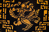 Wat Xieng Thong temple in Luang Prabang, Laos. Detail of the  intricate gold stencilling on black lacquer that decorate the walls of the sim. 